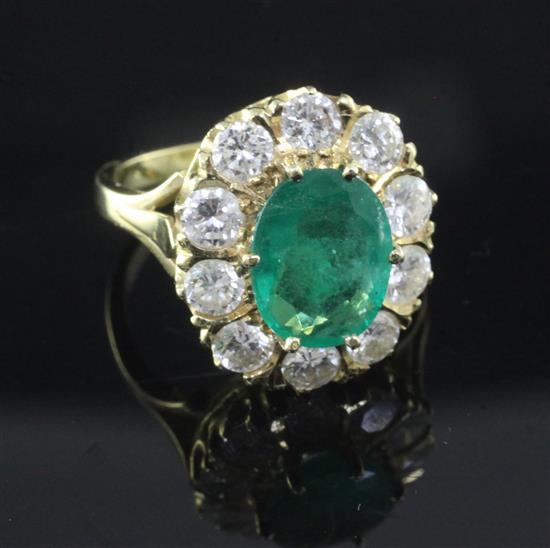 A modern 18ct gold, emerald and diamond oval cluster ring, size O.